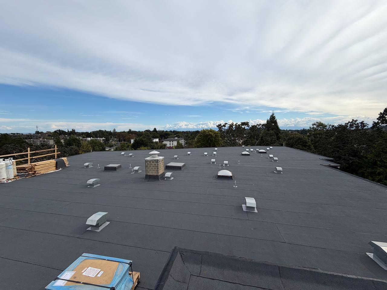 Completed flat roof with new vents and a brick chimney