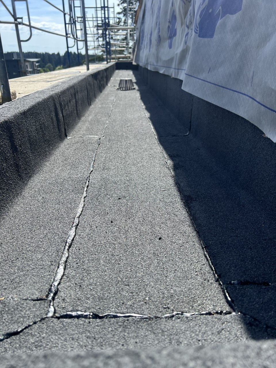 Sealed drainage channel between parapet walls